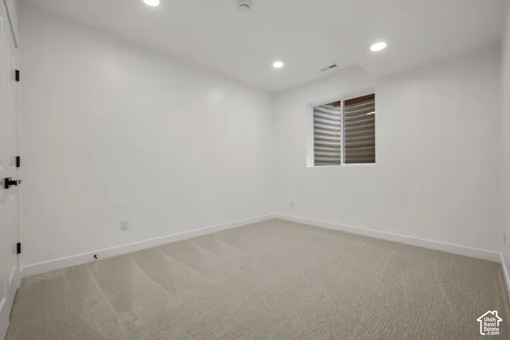 Room featuring neutral-toned carpet, white walls, and recessed lighting