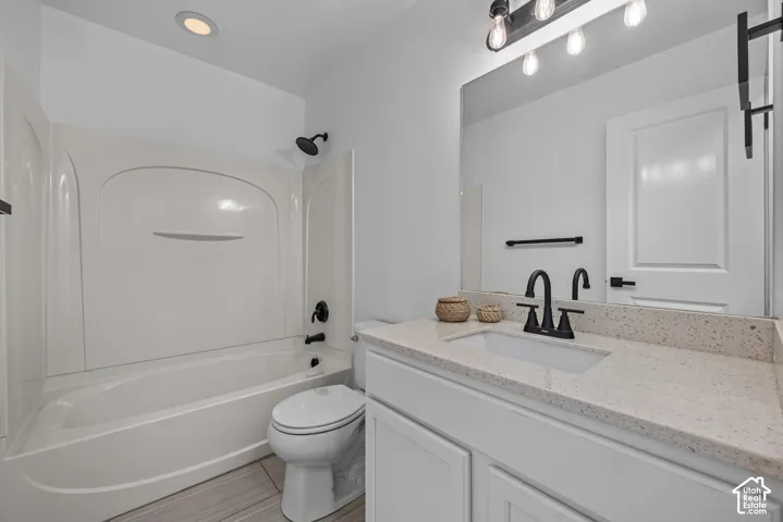 Modern bathroom featuring a white vanity with an integrated sink, a light speckled countertop, and matte black fixtures