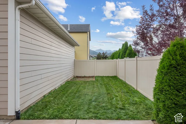 Private backyard space featuring a freshly manicured lawn, full-height privacy fencing, and mature landscaping