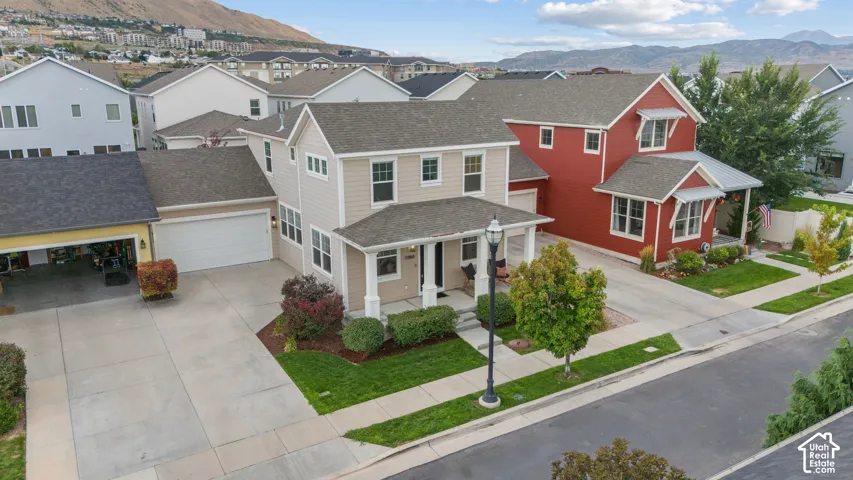 Exterior featuring a covered front porch, a two-car garage, a separate single-car garage, and established landscaping