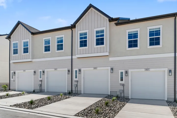 Multi-level facade with light-colored siding and stucco finishes