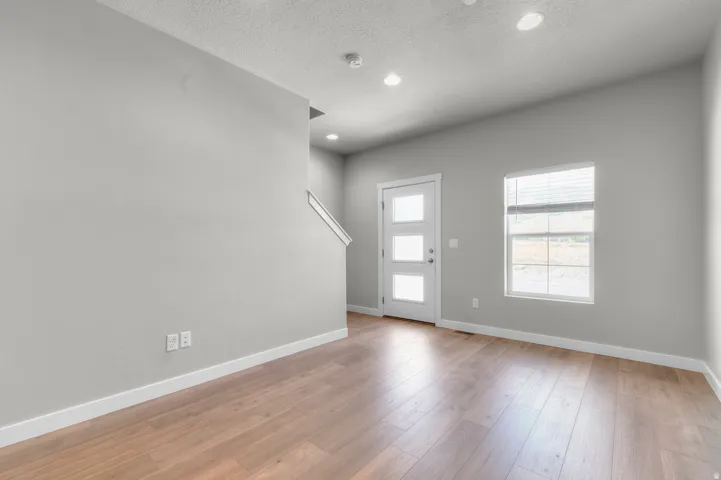 Wood-finish flooring, recessed lighting, and a modern entry door with frosted glass panels