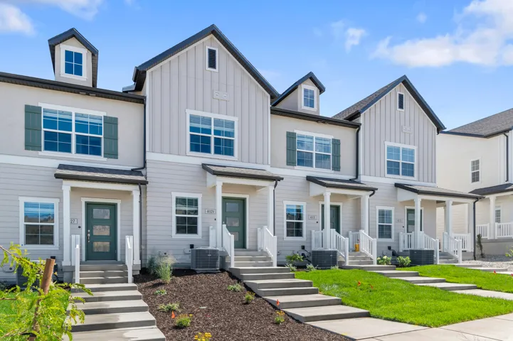 Contemporary townhome facades with gabled roofs, board and batten siding, multiple windows, and covered front porches