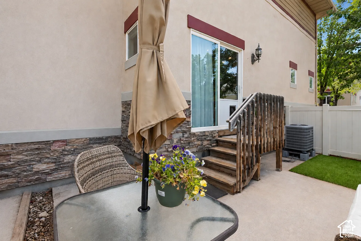 Private patio space featuring a concrete slab and artificial turf