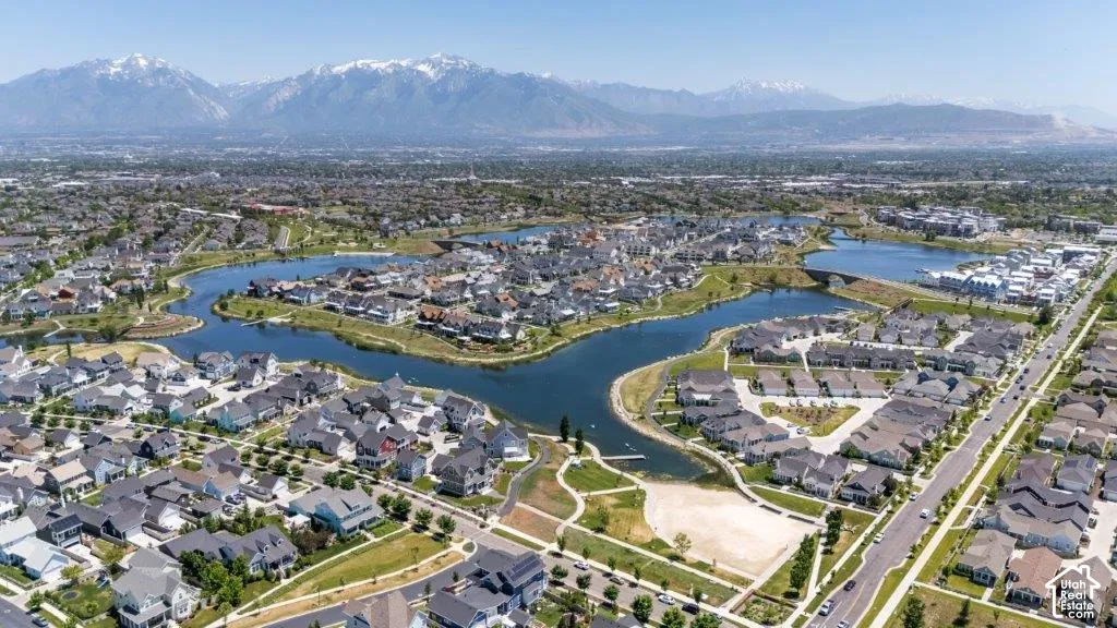 Aerial overview of a residential community featuring a central lake and surrounding homes with varied architectural styles