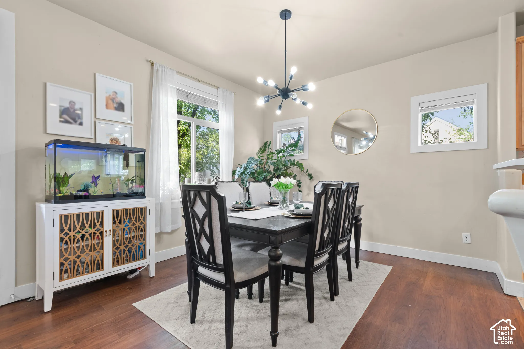 Dining area with wood-finish flooring, neutral wall paint, and a contemporary multi-arm chandelier