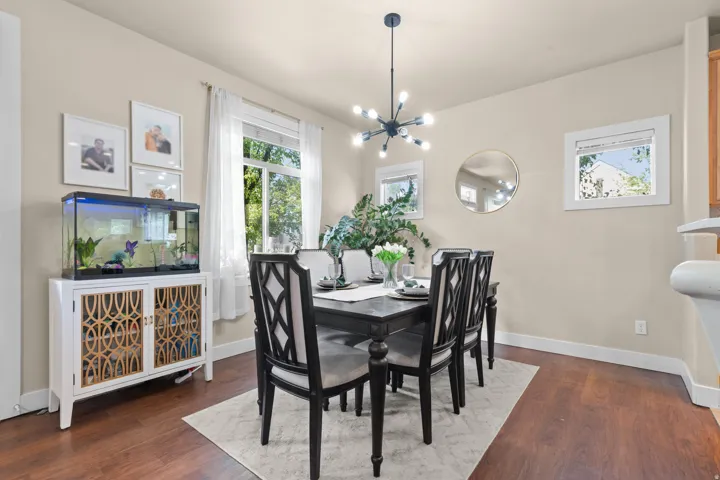Dining area with wood-finish flooring, neutral wall paint, and a contemporary multi-arm chandelier