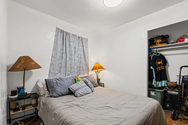 Bedroom featuring light-colored walls and wood-finish flooring