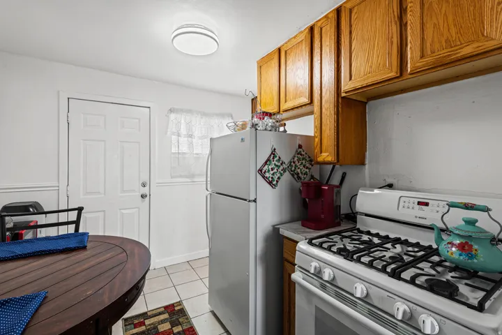 Kitchen featuring wood-finish cabinetry, a white gas range, and a white refrigerator