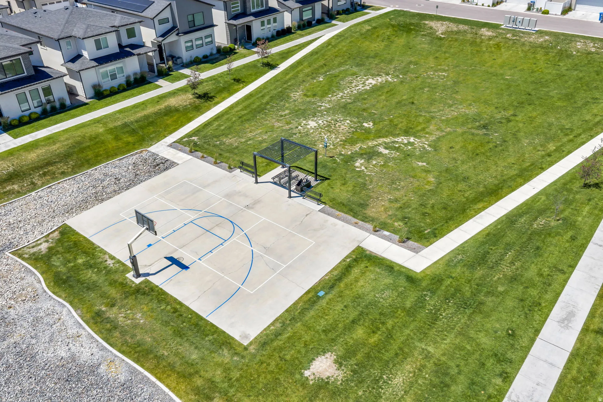 Paved basketball court featuring painted lines and an attached hoop