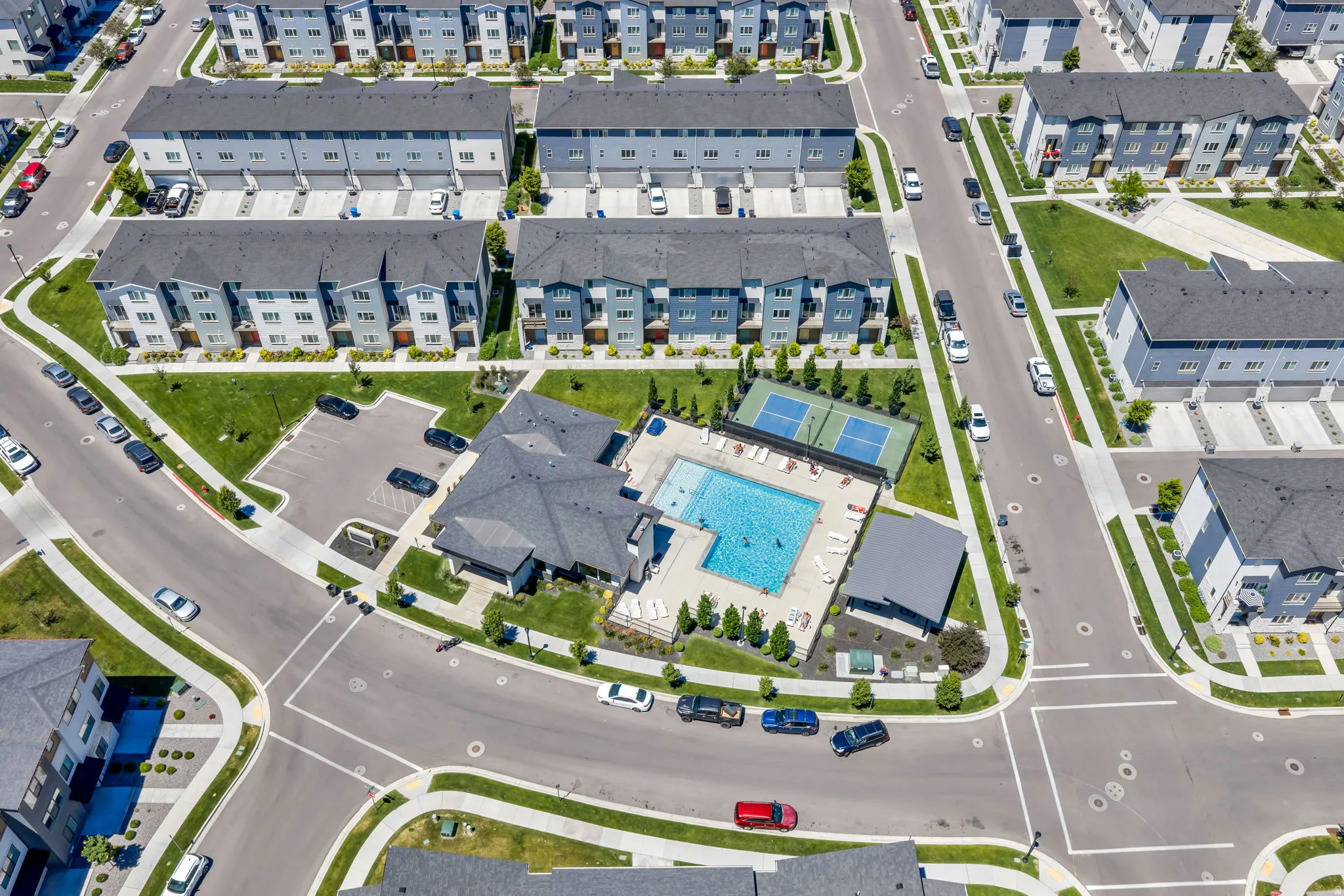 Community amenity center featuring a swimming pool, tennis courts, and a clubhouse building