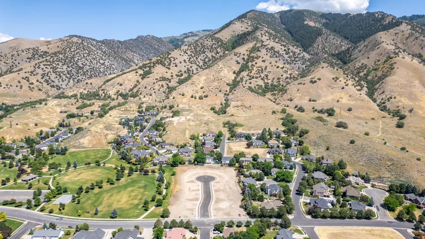 Aerial perspective showcasing a residential development nestled at the base of expansive mountains