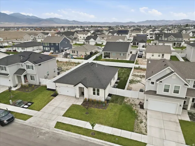 Single-story residence featuring a white stone facade, dark asphalt shingle roof, and an attached two-car garage