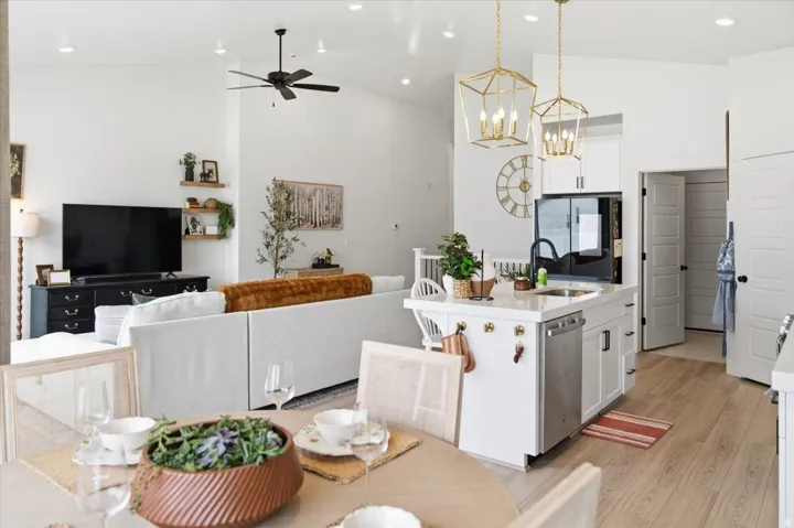 Bright living area featuring vaulted ceilings, recessed lighting, and wood-finish flooring