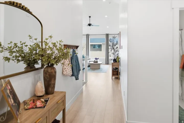 Light wood-finish flooring extending through a bright hallway