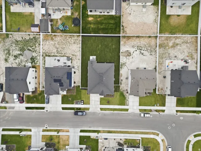 Aerial perspective showcasing a residential neighborhood with paved streets and concrete sidewalks