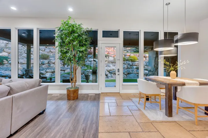 Expansive living area with large windows, a glass-paneled door, and recessed lighting