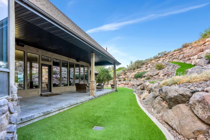 Exterior featuring a concrete patio, stone columns, and an extended overhang