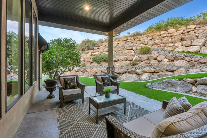 Covered patio with recessed lighting, concrete flooring, and a stone retaining wall