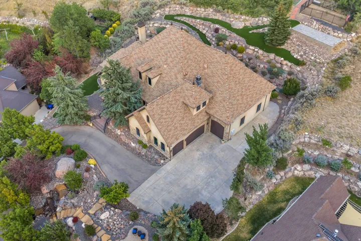 Multi-level exterior with a large driveway, attached two-car garage, and a textured roof