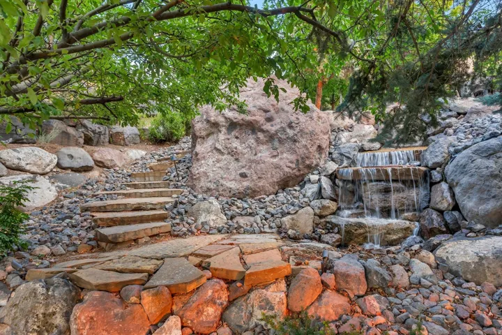 Tiered water feature with natural stone steps and varied rock landscaping