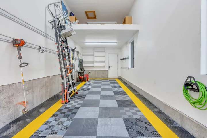 Spacious garage featuring checkered tile flooring with yellow accent strips