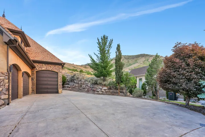 Multi-car garage with arched wooden doors and stone detailing