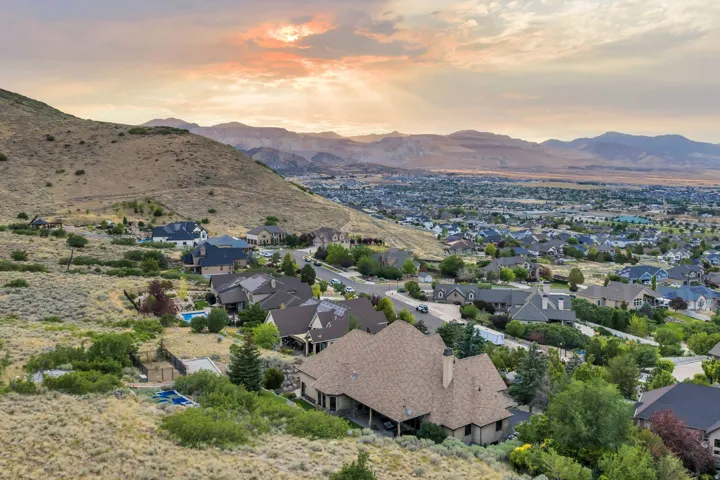 Expansive residential area featuring numerous properties, mountainous terrain, and distant urban development