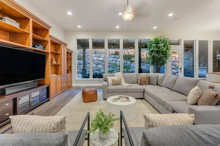 Spacious living area featuring expansive windows, recessed lighting, and wood-finish flooring