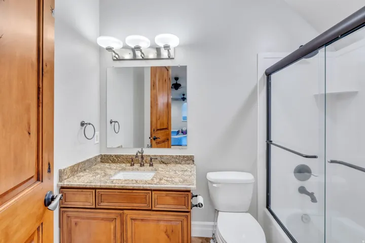 Bathroom featuring a vanity with a stone countertop, an integrated sink, and an oil-rubbed bronze faucet