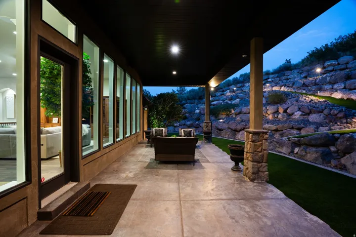 Covered patio with a concrete surface, supported by columns with stone bases
