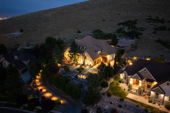 Custom home featuring a multi-gable roofline, stone and stucco exterior, and integrated garage