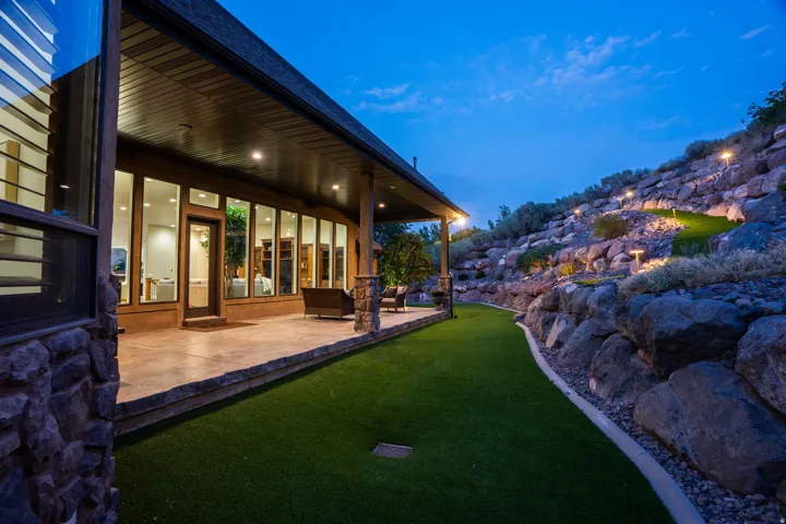 Expansive rear patio featuring a stamped concrete surface, recessed lighting, and a full-length covered design