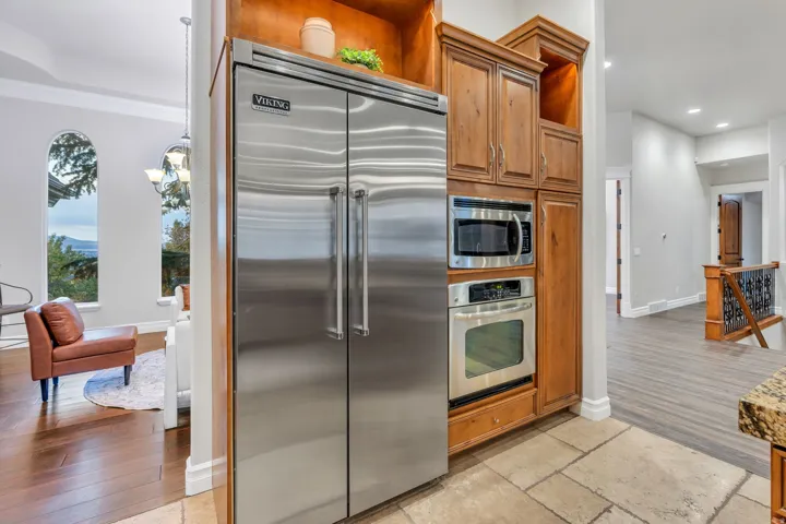 Stainless steel Viking refrigerator and built-in appliances framed by wood cabinetry