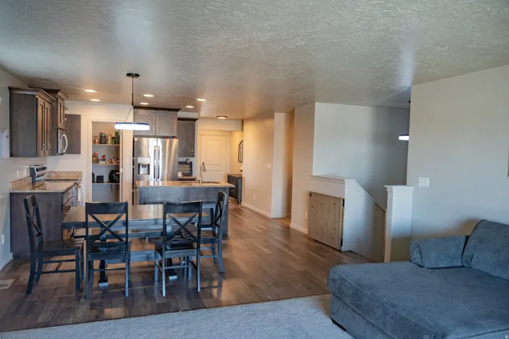 Open-concept kitchen and dining area featuring wood-finish flooring, recessed lighting, and a walk-in pantry