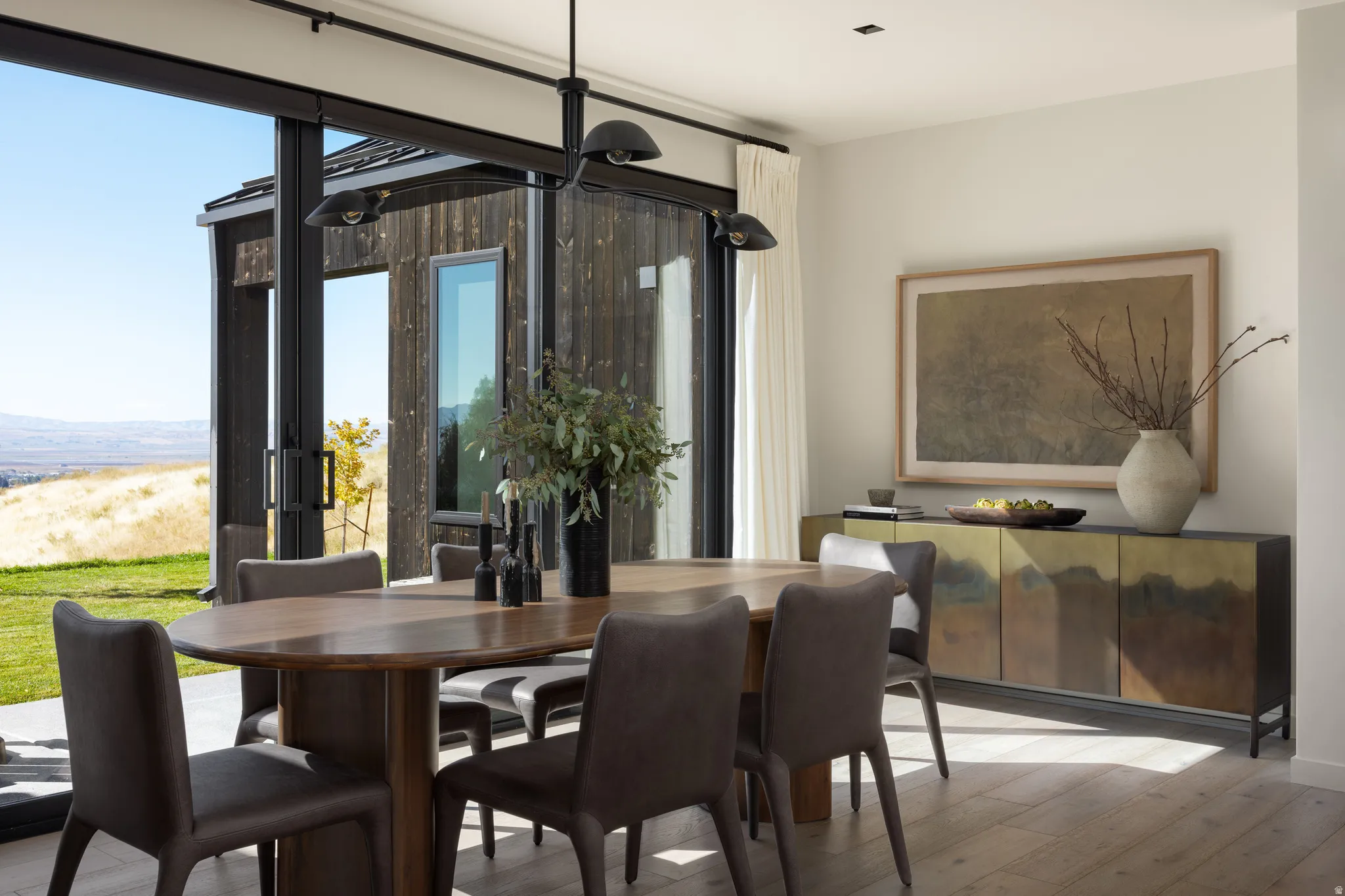 Dining area featuring wide plank wood-finish flooring and a contemporary chandelier