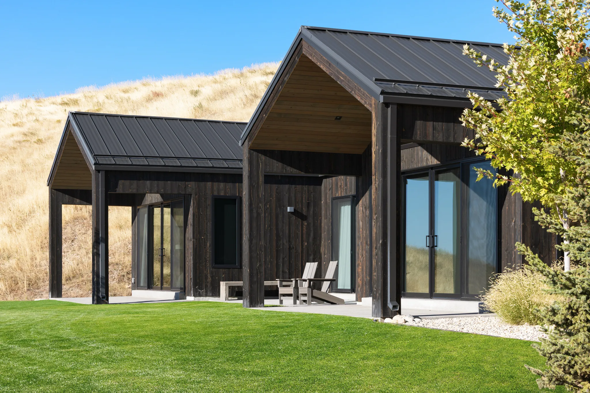 Modern architecture featuring dark wood siding and a black metal roof