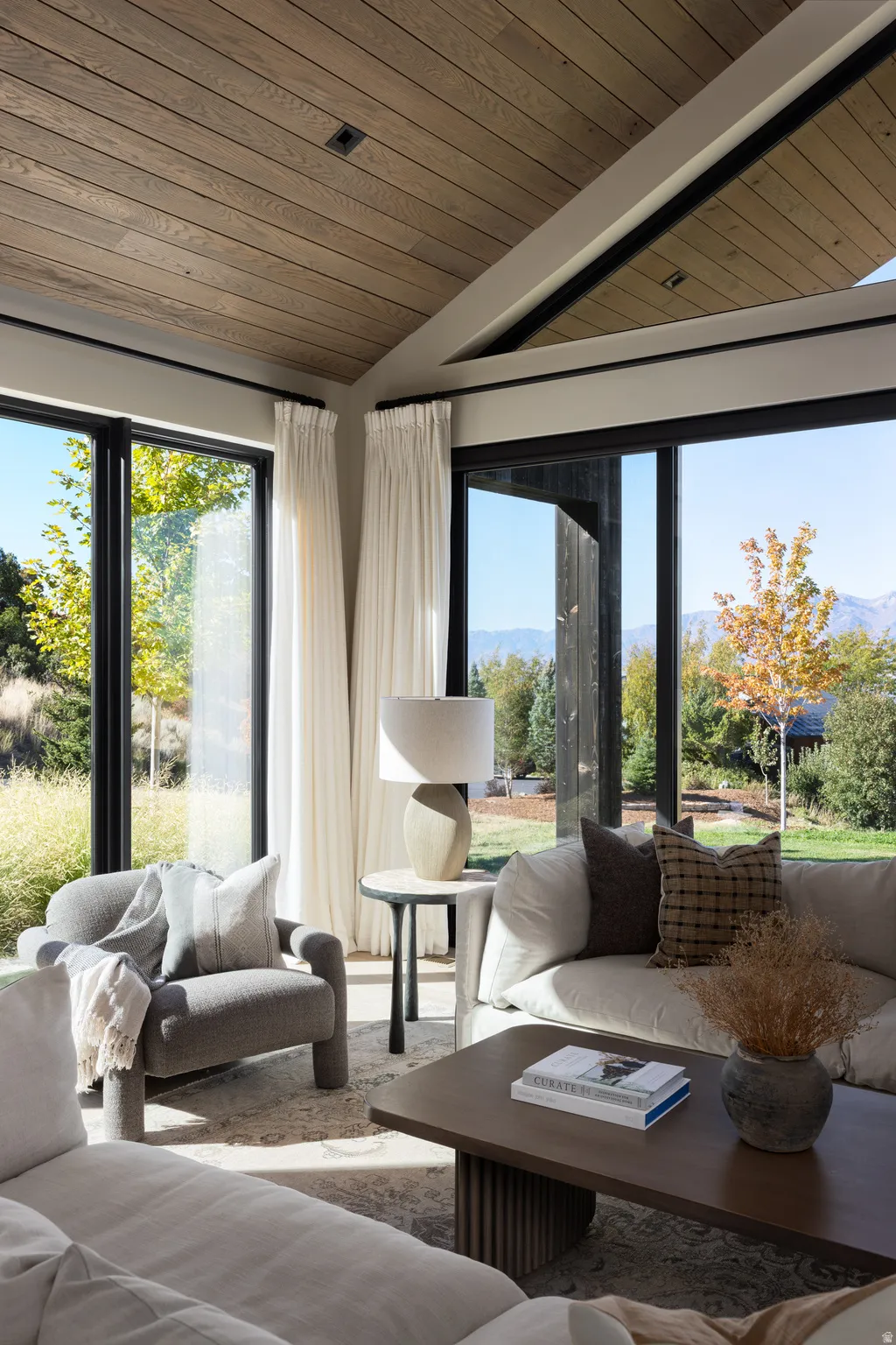 Vaulted wood-finish ceilings complement expansive black-framed windows