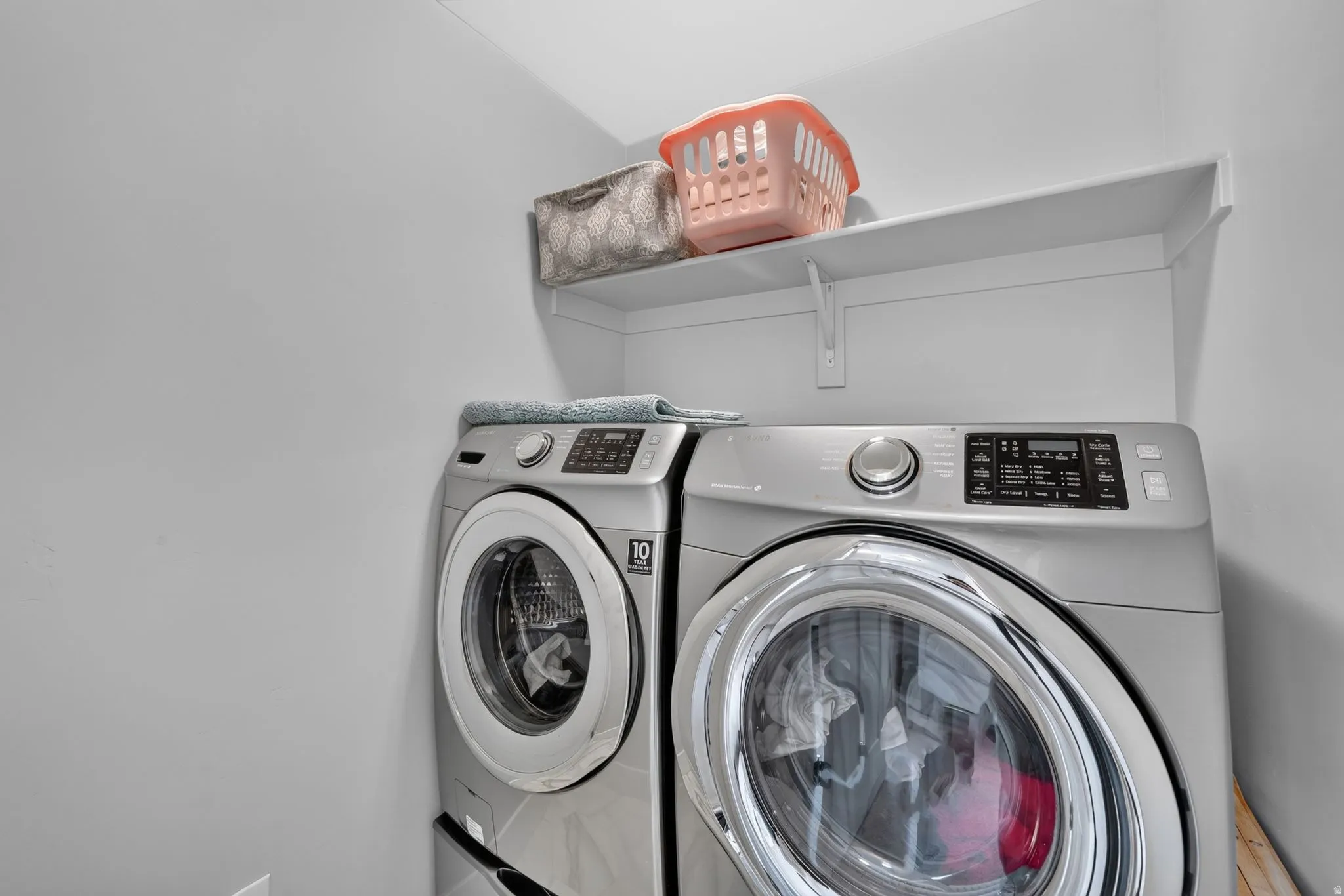 Dedicated laundry area featuring a wall-mounted white shelf