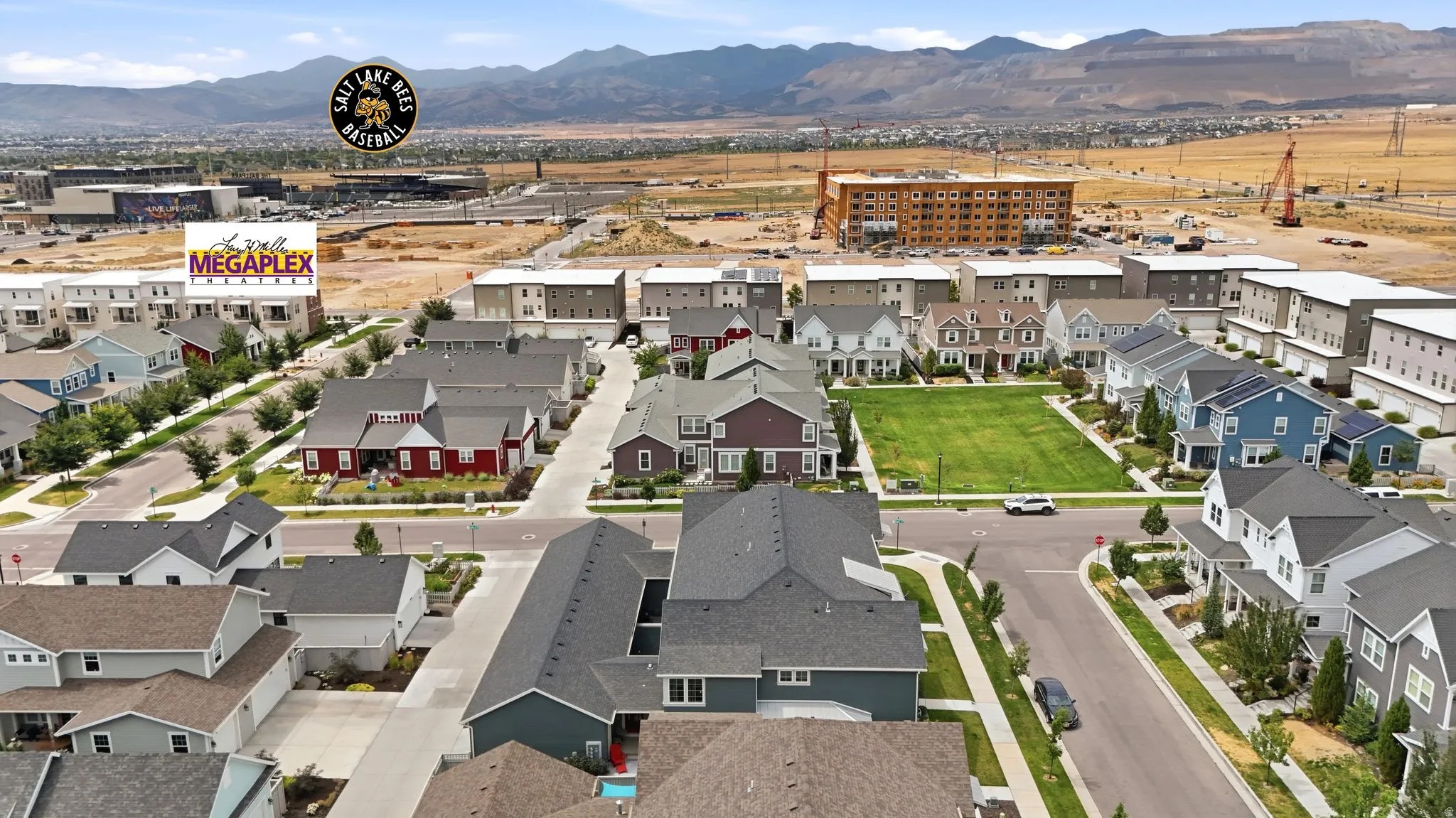Aerial perspective of a developed residential area featuring various home styles and a central green space