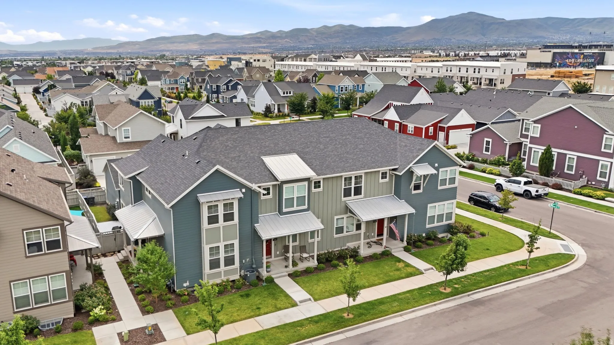 Contemporary multi-family residence featuring a dark gray asphalt shingle roof and light gray siding with contrasting darker panels