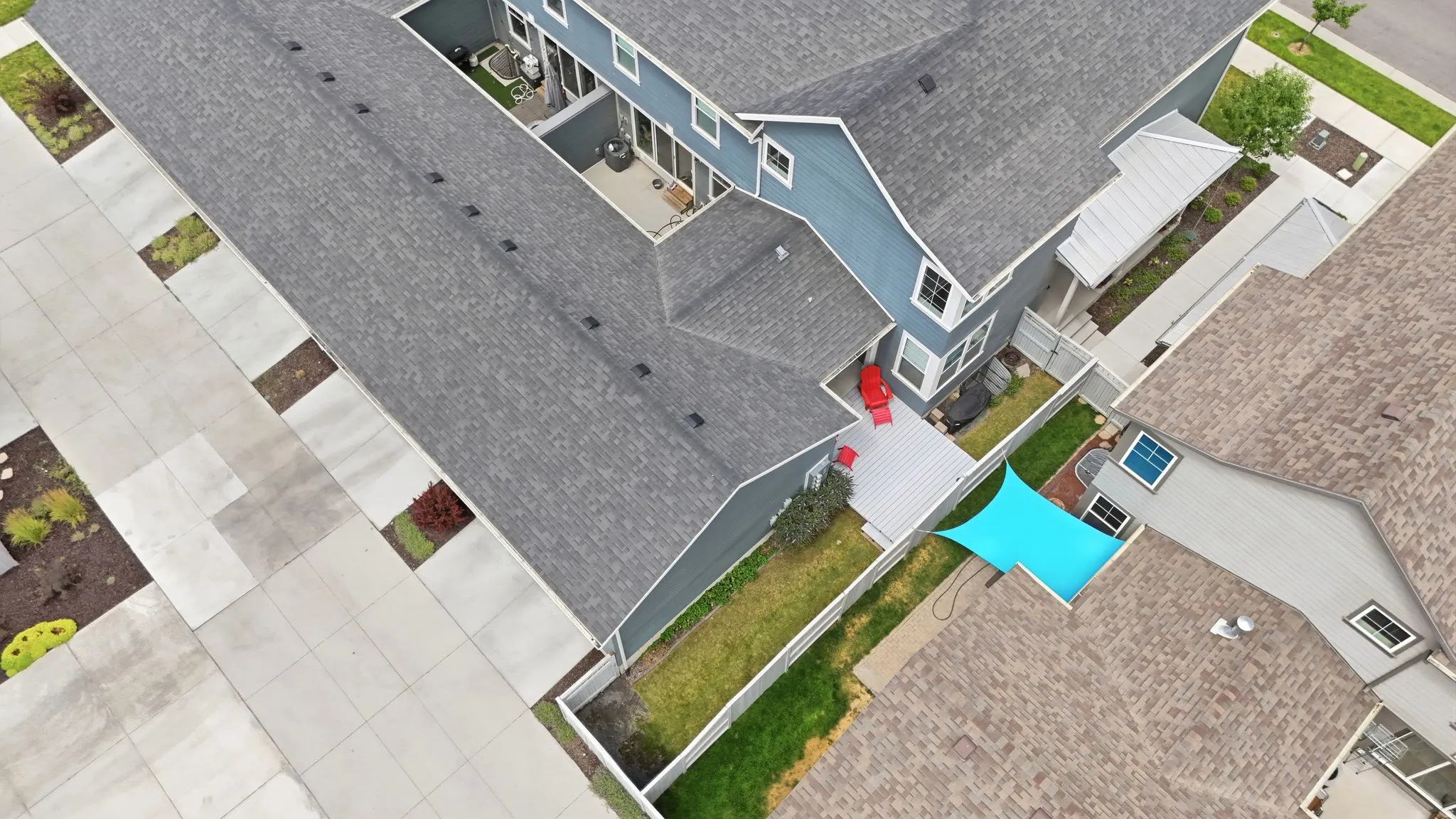 Contemporary multi-story property featuring dark gray shingle roofing and blue-gray siding