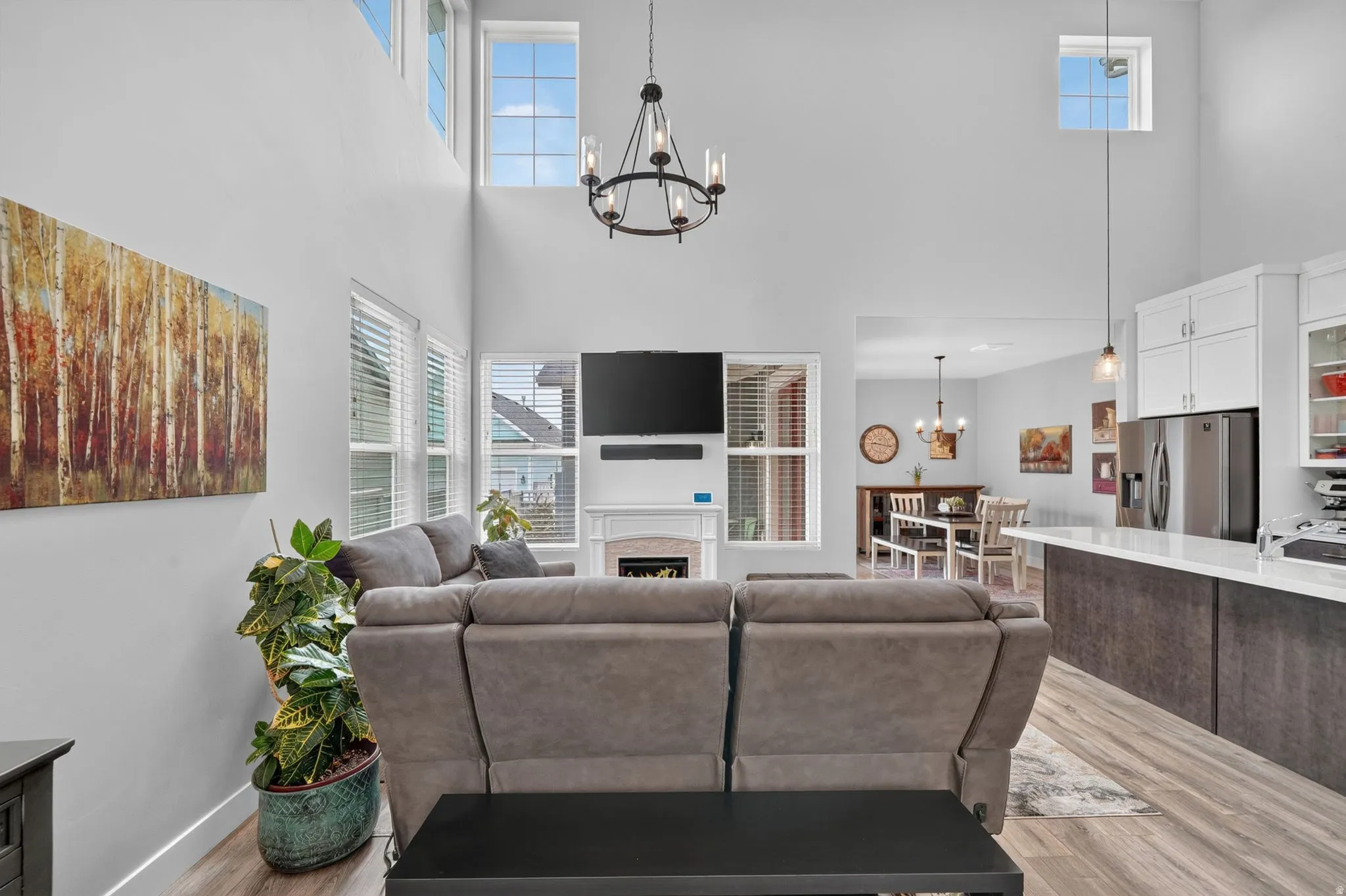 Two-story ceiling in the living area featuring high windows and a decorative chandelier