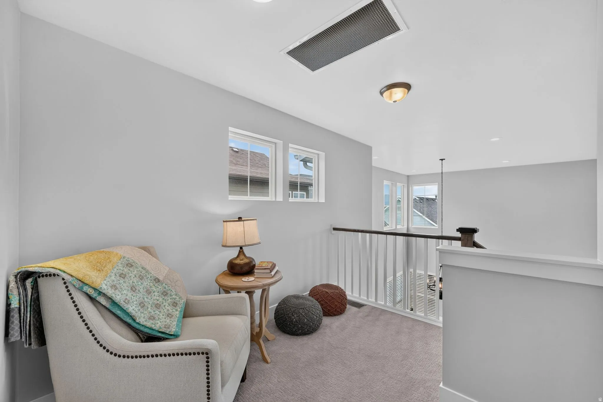 Upper-level landing featuring light gray painted walls and neutral carpet flooring