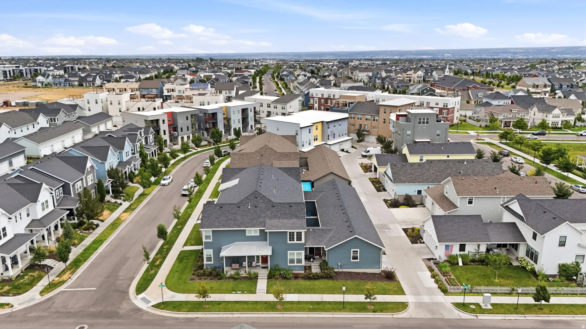 Expansive residential neighborhood featuring a mix of single-family homes and multi-story buildings, established landscaping, and a curvilinear street layout
