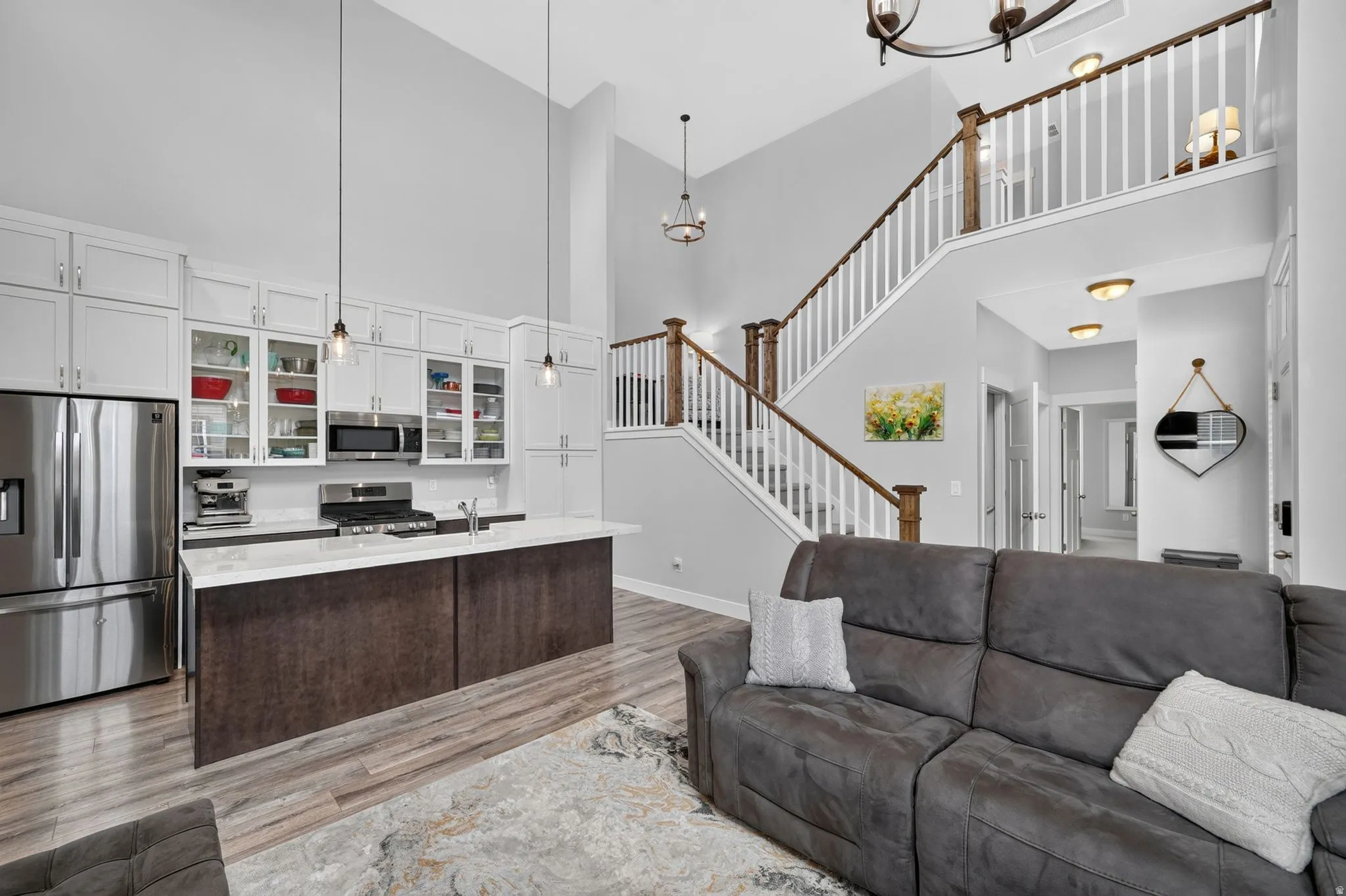 Open-concept living space featuring a two-story ceiling, a contemporary kitchen, and a grand staircase