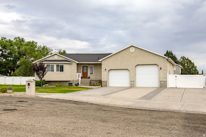 Stucco exterior featuring an extra-long two-car garage with an extra-tall bay and an additional one car garage.