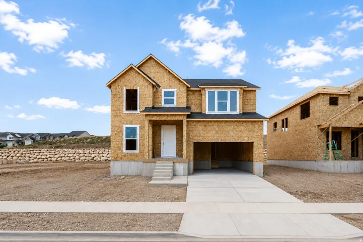 Two-story construction featuring a front porch, an attached garage, and a concrete driveway