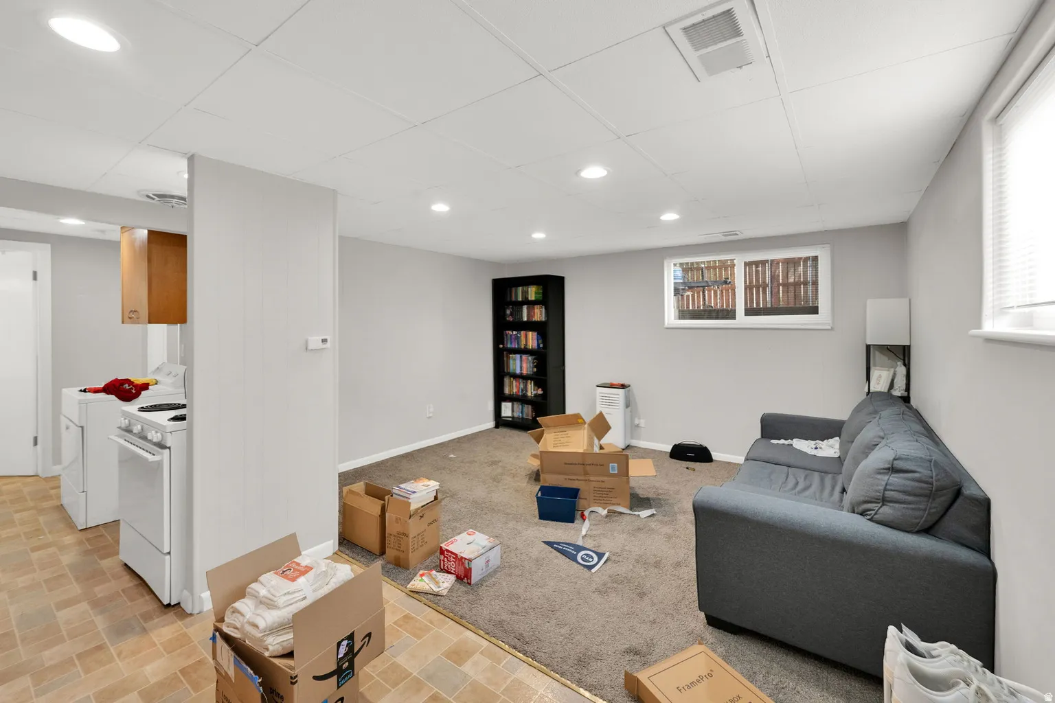 Finished basement with light gray walls, recessed lighting, and a drop ceiling