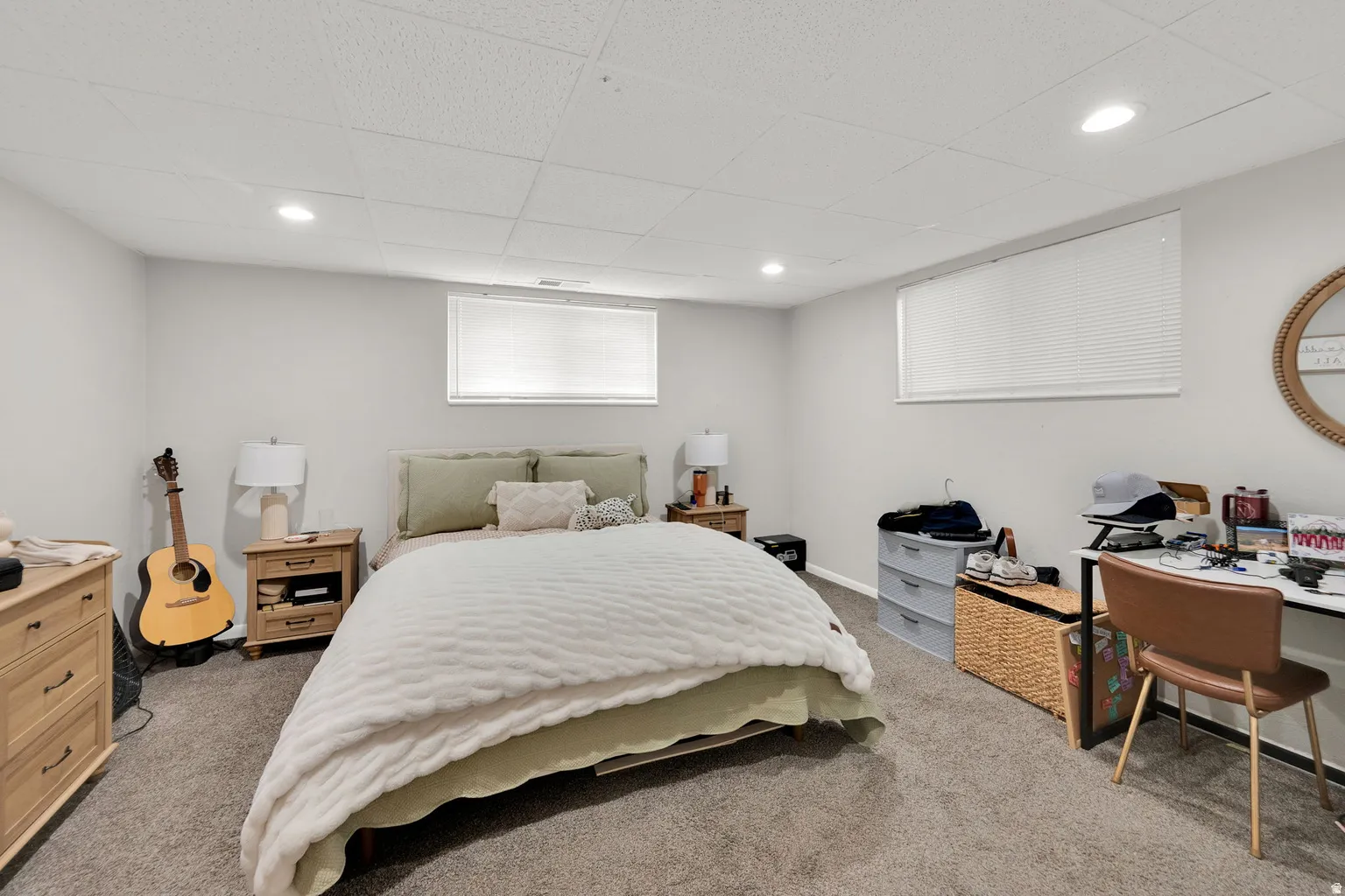 Carpeted room with light gray walls, recessed lighting, and two horizontally oriented windows featuring white blinds